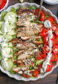 a salad with chicken, cucumber and tomatoes in a bowl