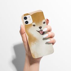 a woman holding up a phone case with a dog on it's face and tongue sticking out