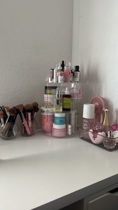 a white counter topped with lots of cosmetics and personal care items on top of it