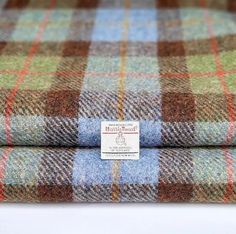 two plaid fabric with a label on the front and back of each piece in different colors