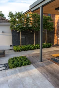 an outdoor living area with wooden benches and plants