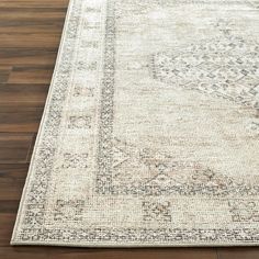 an area rug on the floor with wooden floors and wood planks in the background