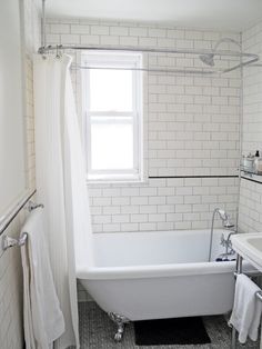 a bathroom with a white tub sitting next to a window