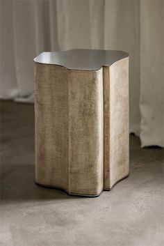 the side table is made out of metal and has a curved design on it's sides