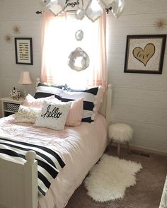 a bed room with a neatly made bed and pictures hanging on the wall above it