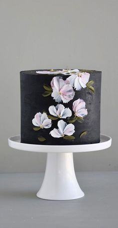 a black and white cake with pink flowers on it