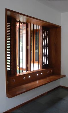 an empty room with wooden shutters on the window sill and windows in the wall