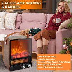 a woman sitting on a couch next to an electric fireplace heater and christmas tree