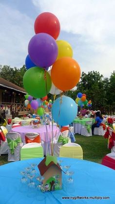 there are many balloons in the center of this table with a house on it and other decorations