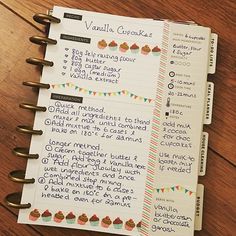 a recipe book with cupcakes on it sitting on top of a wooden table