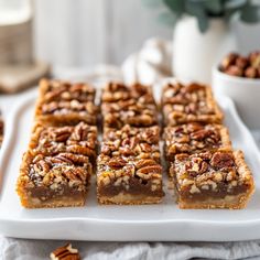 several pieces of pecan pie on a white platter