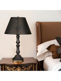 a lamp on a nightstand next to a bed