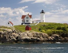 two lighthouses on top of a rocky outcropping next to the ocean