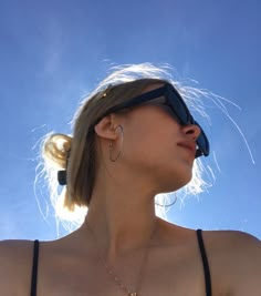 a woman wearing sunglasses looking up into the sky