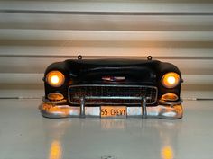 an old model car is shown with its headlights turned on and the license plate reads 55 chevy