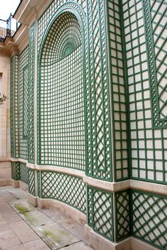 an intricately designed wall in the middle of a courtyard with tiled floors and walls