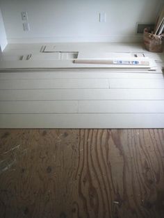 an unfinished kitchen counter top with wood flooring in the foreground and white walls