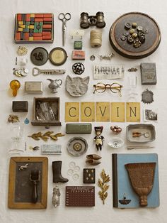 an assortment of items are displayed on a white tablecloth with the word covin written in cursive letters