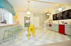 the kitchen is clean and ready for customers to use it's counter tops, stools, and chalkboard