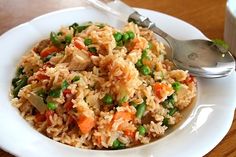 a white plate topped with rice and veggies next to a cup of coffee