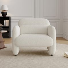 a white chair sitting on top of a rug in a living room next to a lamp