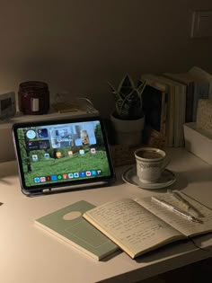 an open laptop computer sitting on top of a desk next to a cup of coffee