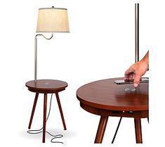 a table with a phone on it and a lamp next to it that is plugged in