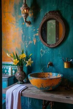 a bathroom with blue walls and yellow flowers in a bowl on the counter next to a mirror