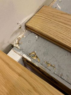 the corner of an unfinished room with wood flooring