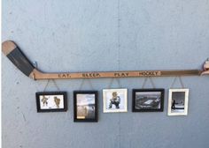 a hockey stick hanging from the side of a wall with pictures on it and an inscription that reads eat sleep play hockey