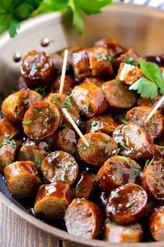 a pan filled with meatballs covered in sauce and garnished with parsley