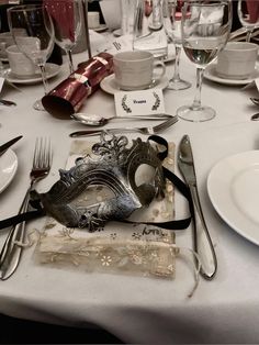 a table set with silverware and masks on it