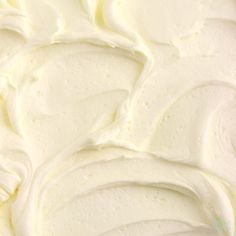 a close up view of white frosting on a cake