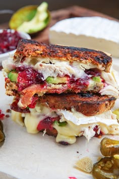 a sandwich cut in half sitting on top of a cutting board next to pickles