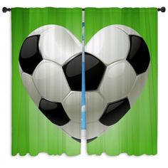 a heart - shaped soccer ball hanging on the side of curtains in front of a green background