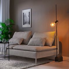 a living room scene with focus on the couch and floor lamp in the foreground