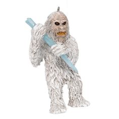 a white furry creature holding a blue toothbrush