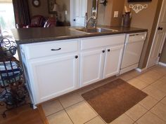 a clean kitchen with white cabinets and black counter tops is seen in this image from the doorway