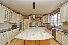 a large kitchen with an island in the middle and lots of cabinets on both sides