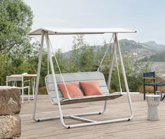 a swing chair sitting on top of a wooden deck