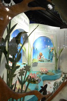 an image of a display in a store window with fake plants and animals on it