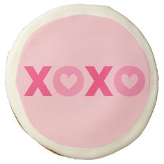 a pink and white cookie with the word xoxo written in large letters on it