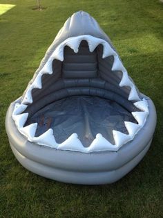 an inflatable shark swimming pool on the grass