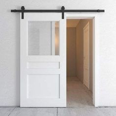 an open white door on the side of a wall next to a light brown door