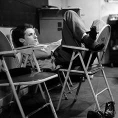 a man laying on top of a folding chair