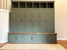 an empty room with green cupboards and carpet on the floor in front of it