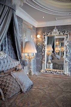 a fancy bedroom with an ornate bed, chandelier and mirror in the corner