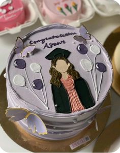 a cake decorated with an image of a woman wearing a graduation cap on top of it