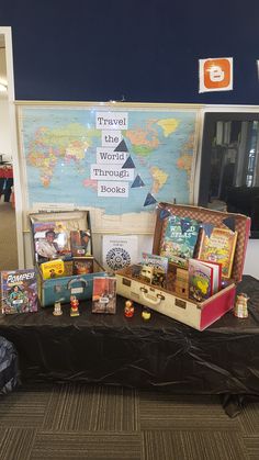 there is a table that has many different items on it, including suitcases and books