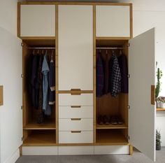 an open closet with clothes hanging on the doors